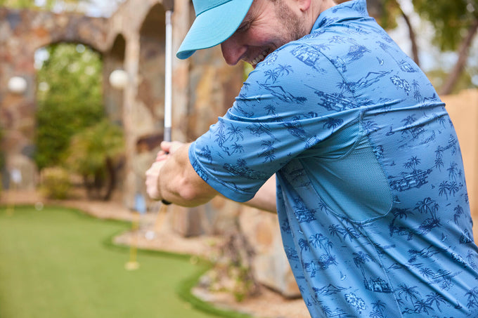 Close-up of a golfer at a resort wearing UV Skinz performance polo and GOLO snapback hat, demonstrating effective sun protection on the course