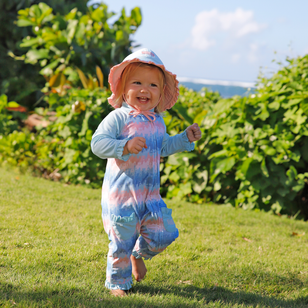 baby girl running in grass in reversible swim hat in aquamarine dusty pink|aquamarine-dusty-pink