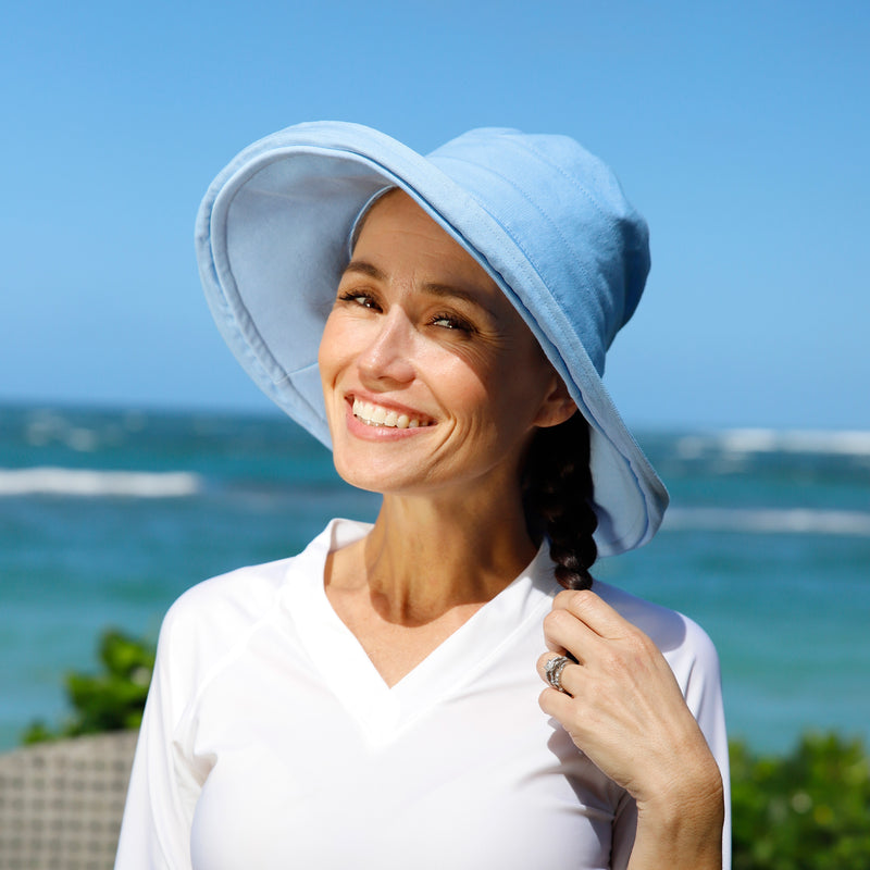 woman posing by the beach in wide brim sun hat|chambray-blue