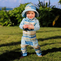 baby boy in grass in reversible sun hat in pinecrest stripe|pinecrest-stripe