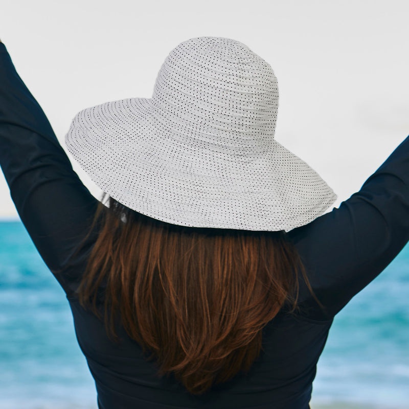 Woman in UV Skinz's wide brim sun hat|white